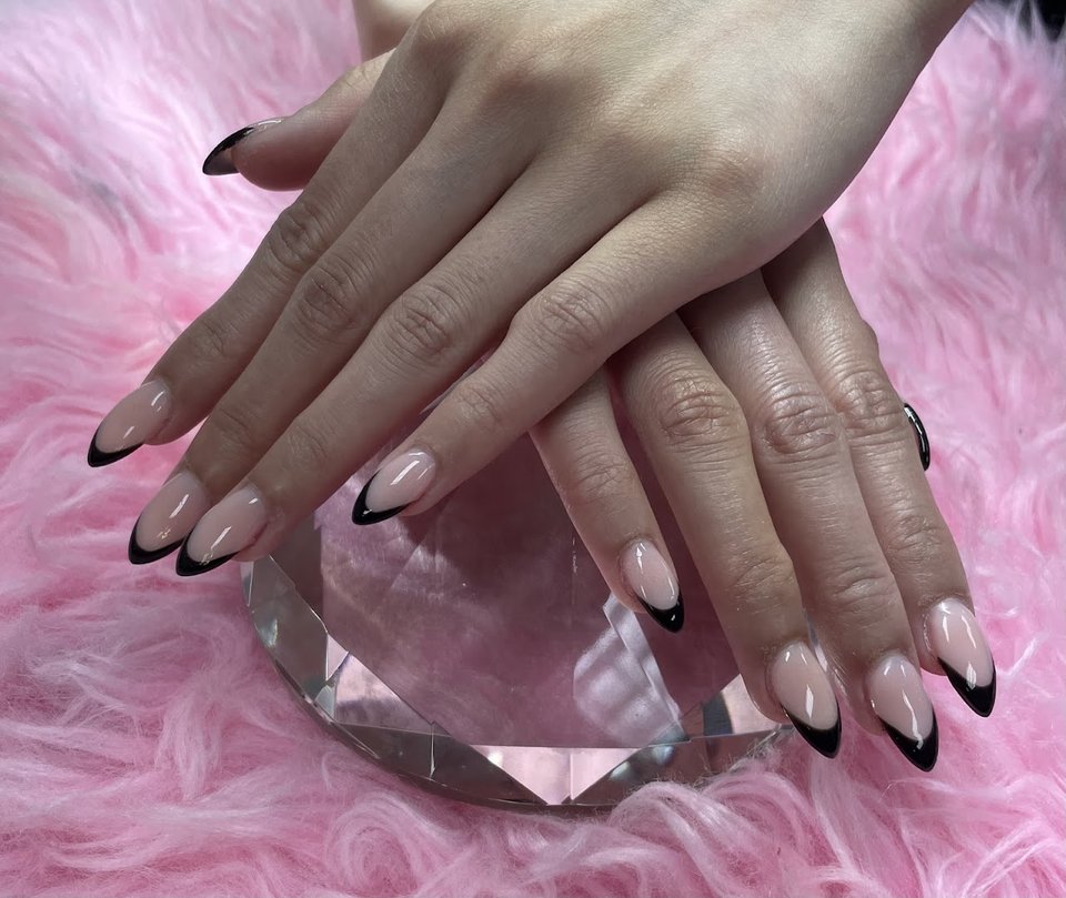 Nail technician shaping nails during an appointment.